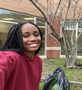 Image of Maryanne Onianwah smiling at the camera in front of a garden